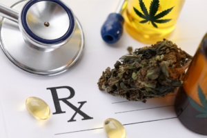 Healthy medical cannabis is represented by a doctor’s stethoscope, prescription pad, capsules, a bud, and two infused oil tinctures